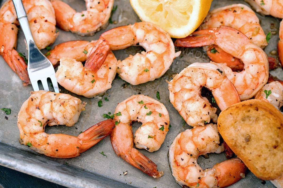 cooked prawns on a silver baking sheet.