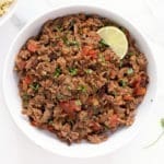 Large bowl of carne picada with a wedge of lime.