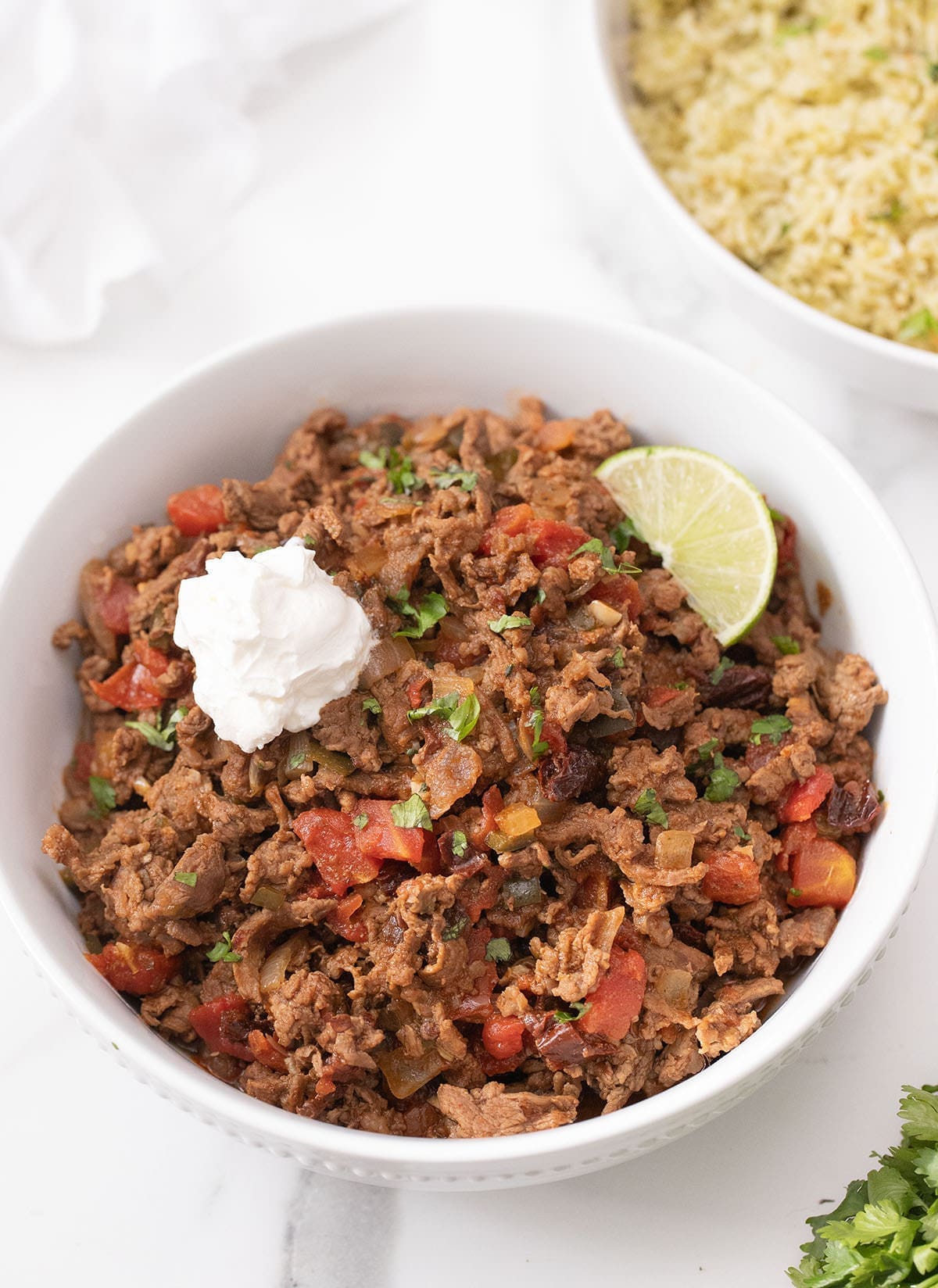 Bowl of beef picado topped with sour cream.