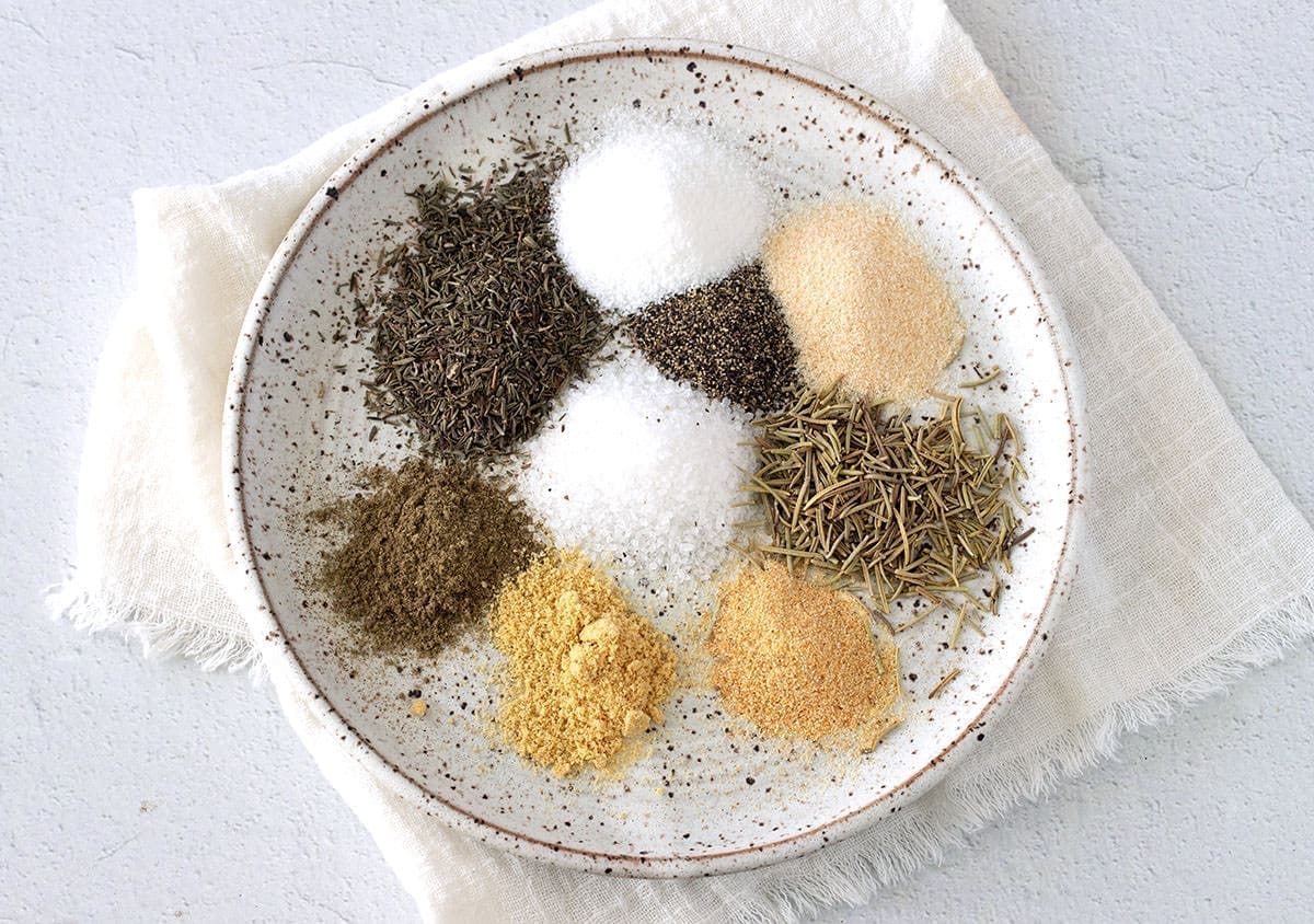 Various spices to make a turkey rub on a deckled plate.