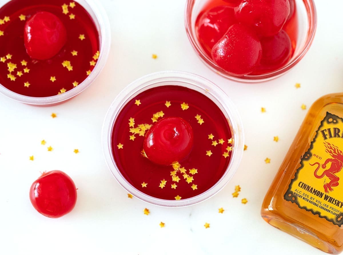 Fireball Jello Shots topped with glitter and a cherry.