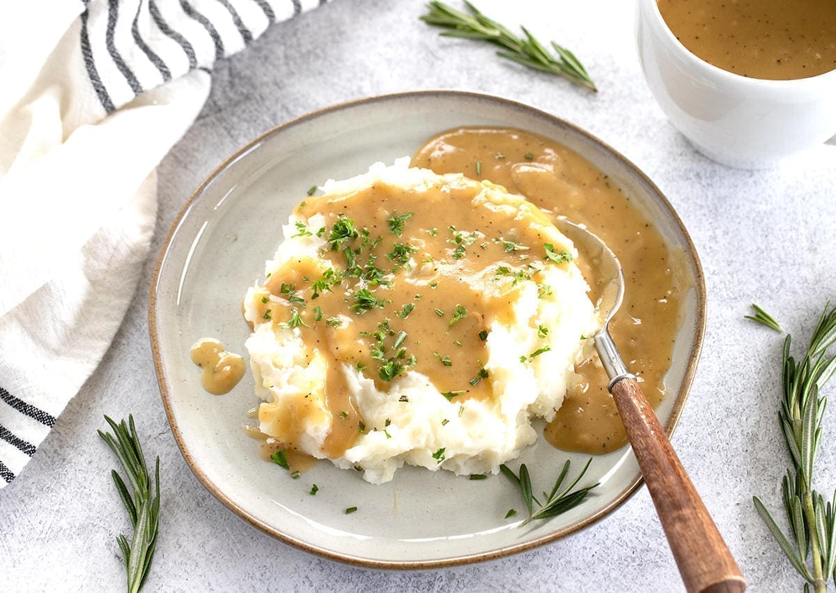 Plate of mashed potatoes with turkey gravy.