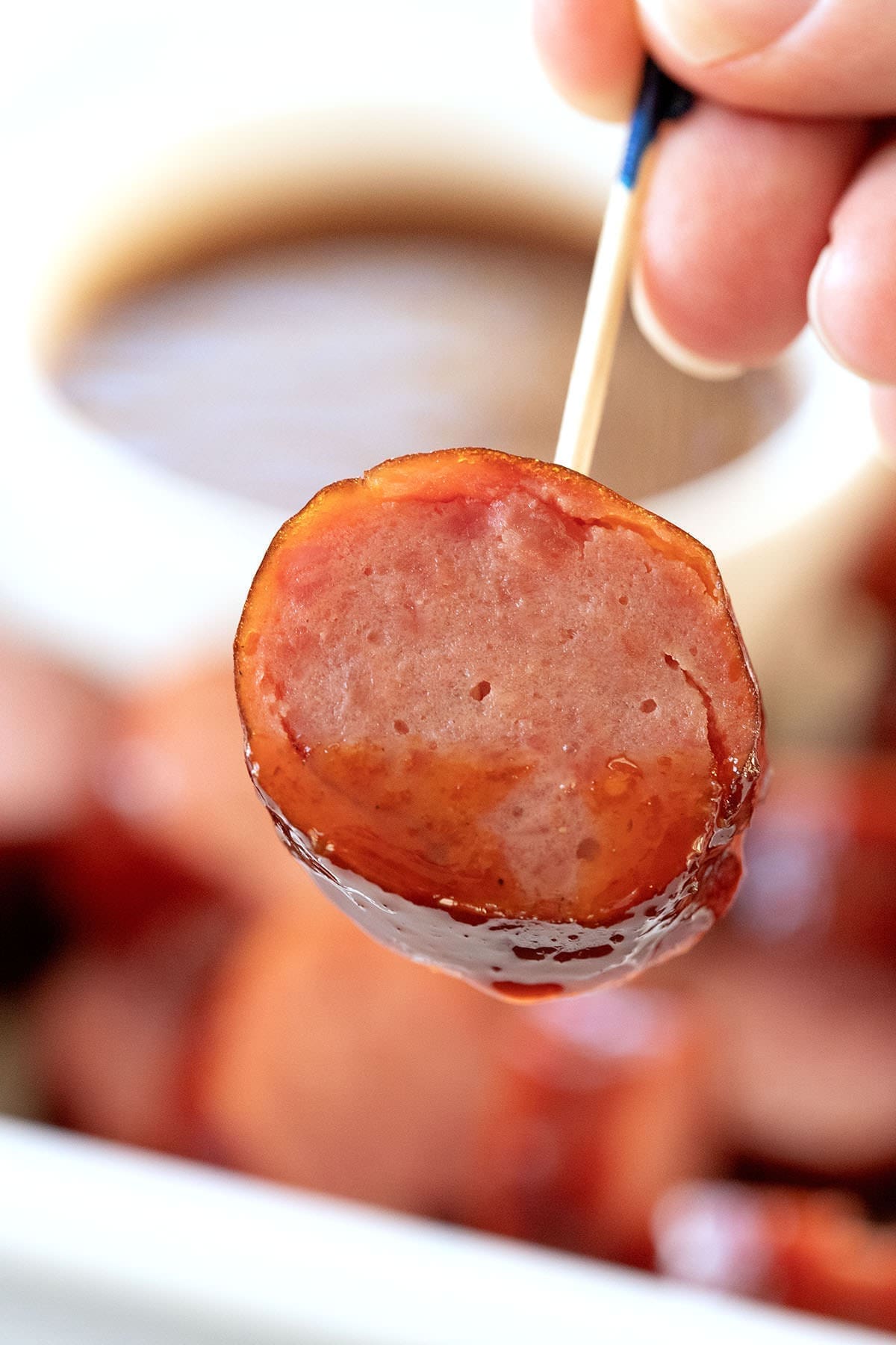 Sliced sausage dipped in BBQ sauce.