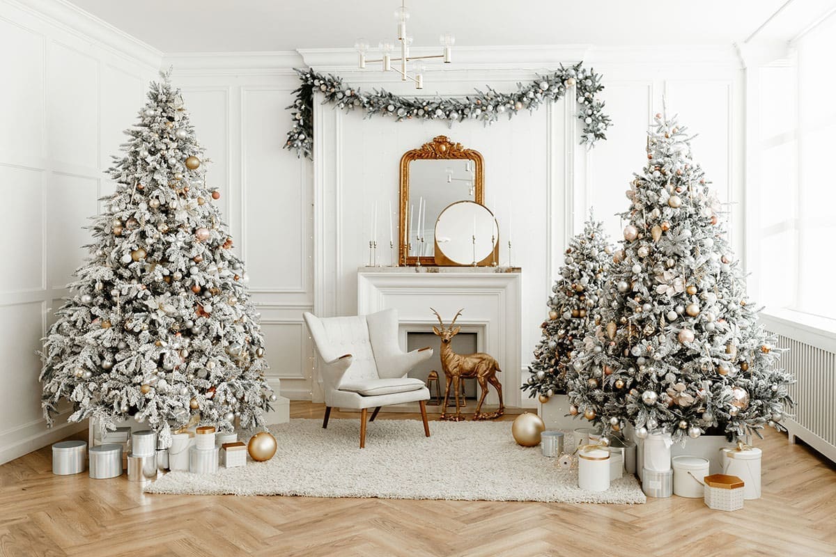 Two white christmas trees and a fireplace for a Christmas themes post.