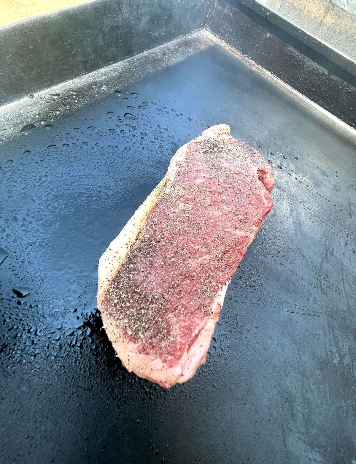 cooking steak on a griddle.