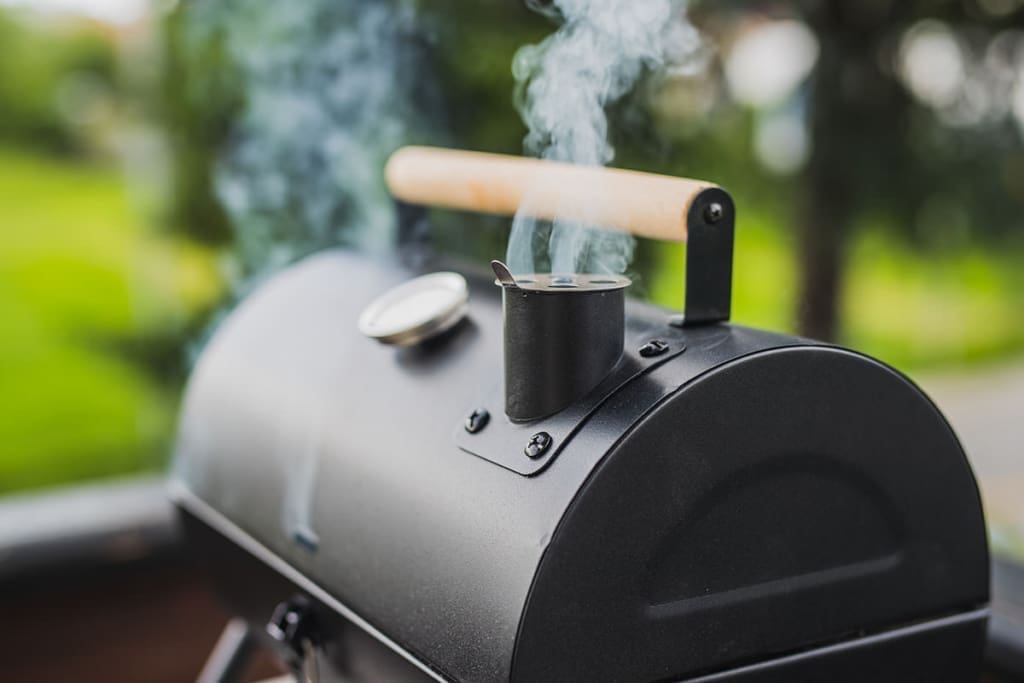 smoke coming out of a Smoker grill for smoker accessories article and best wood for smoking prime rib article.