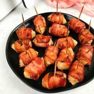 Bacon wrapped pineapple with toothpicks.