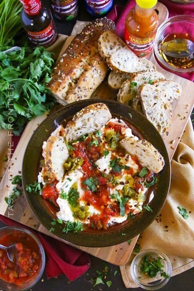 Cream cheese, salsa and bread in a small cast iron pan.