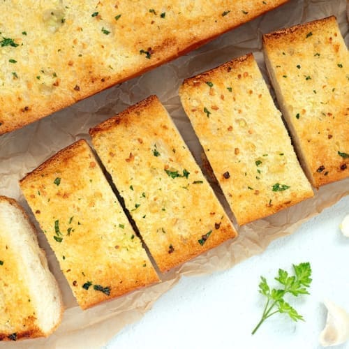 Two loafs of garlic bread garnished with parsley.