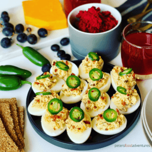 Deviled eggs topped with jalapeno slices.
