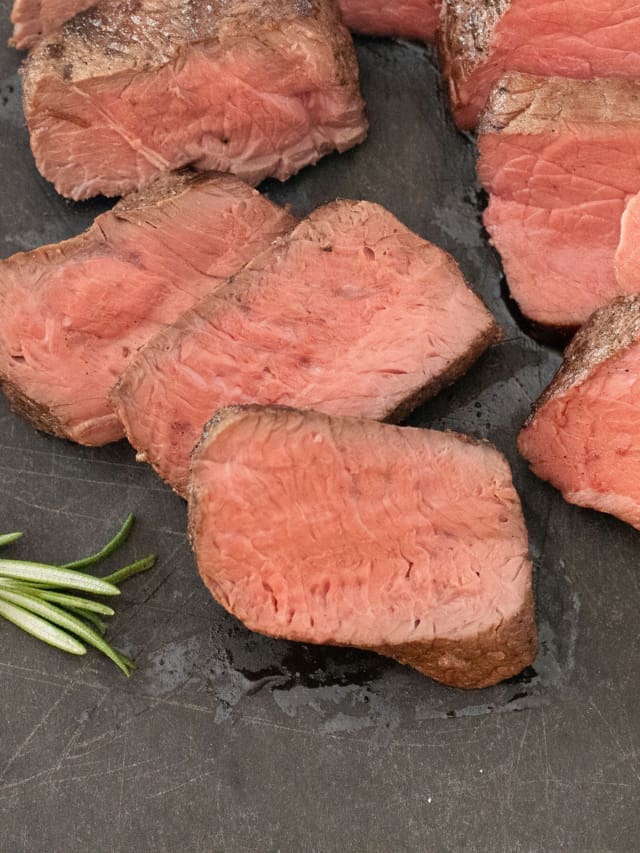 Cut steak on a cutting board.