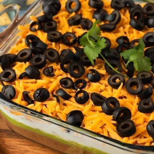 5 layer taco dip in a clear bowl.