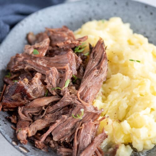 30+ Beef Chuck Roast Recipes 5 Pressure cooker pot roast served on a blue plate.
