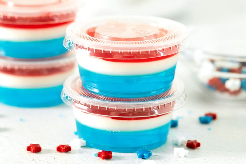 red white and blue jello shots stacked on top of each other.