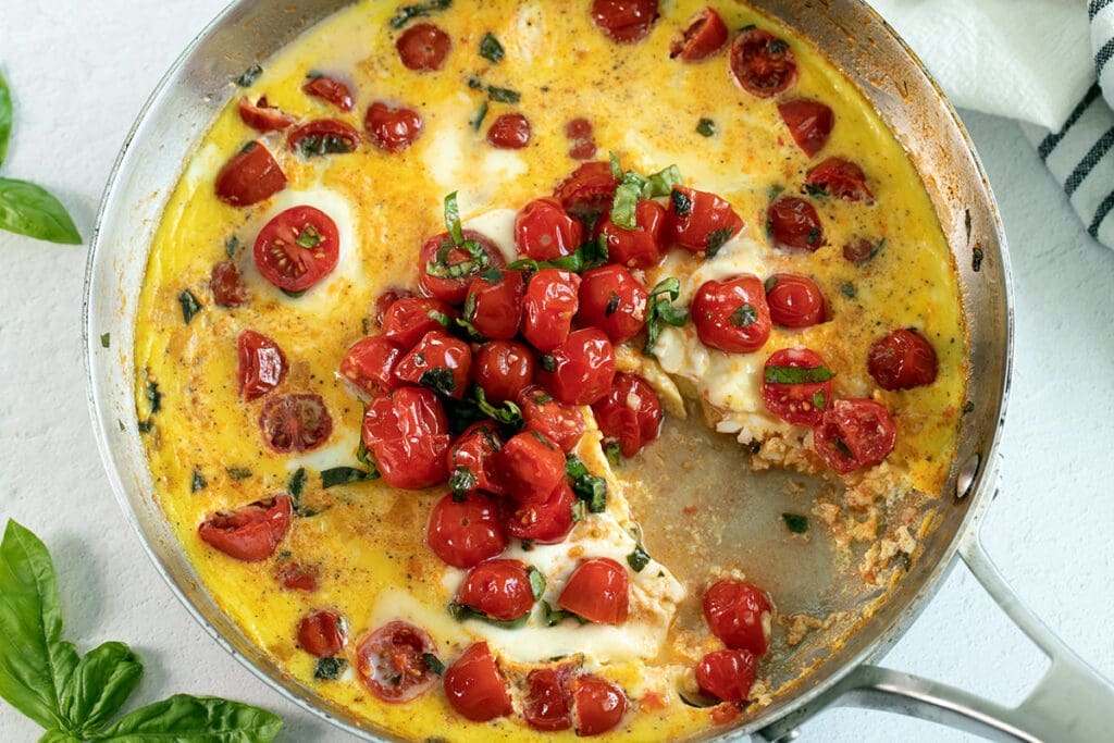 Baked Frittata in a silver skillet with a piece removed.