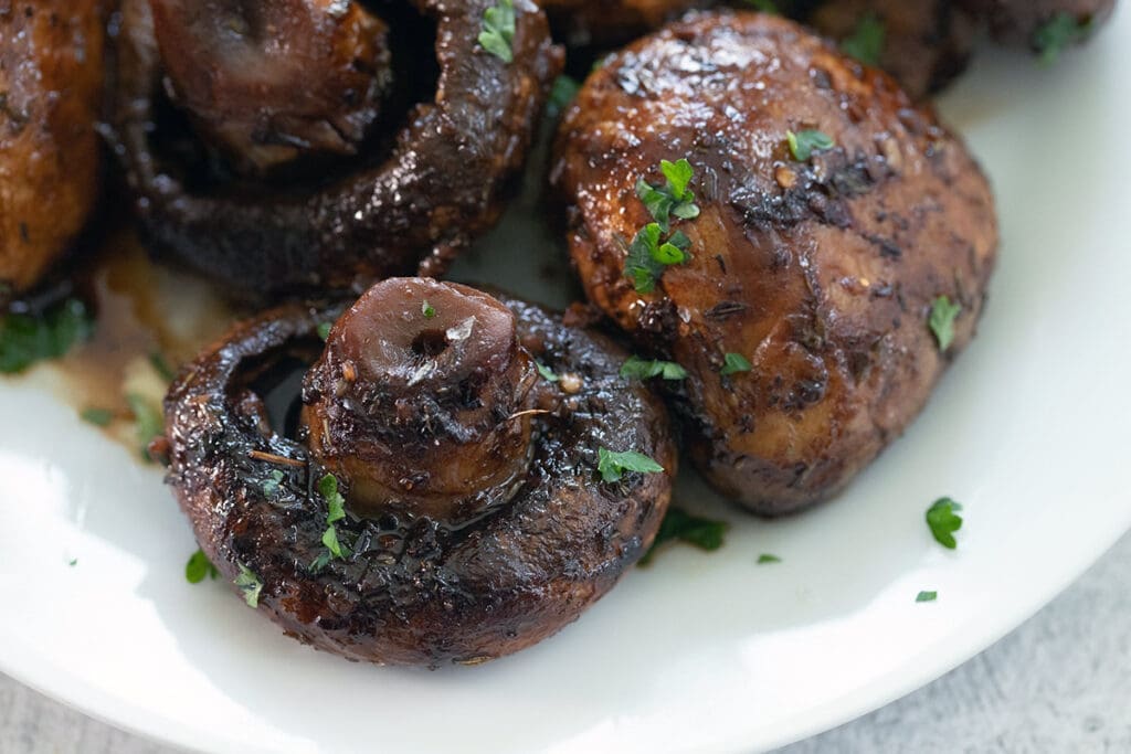 red wine mushrooms on a white serving plate.