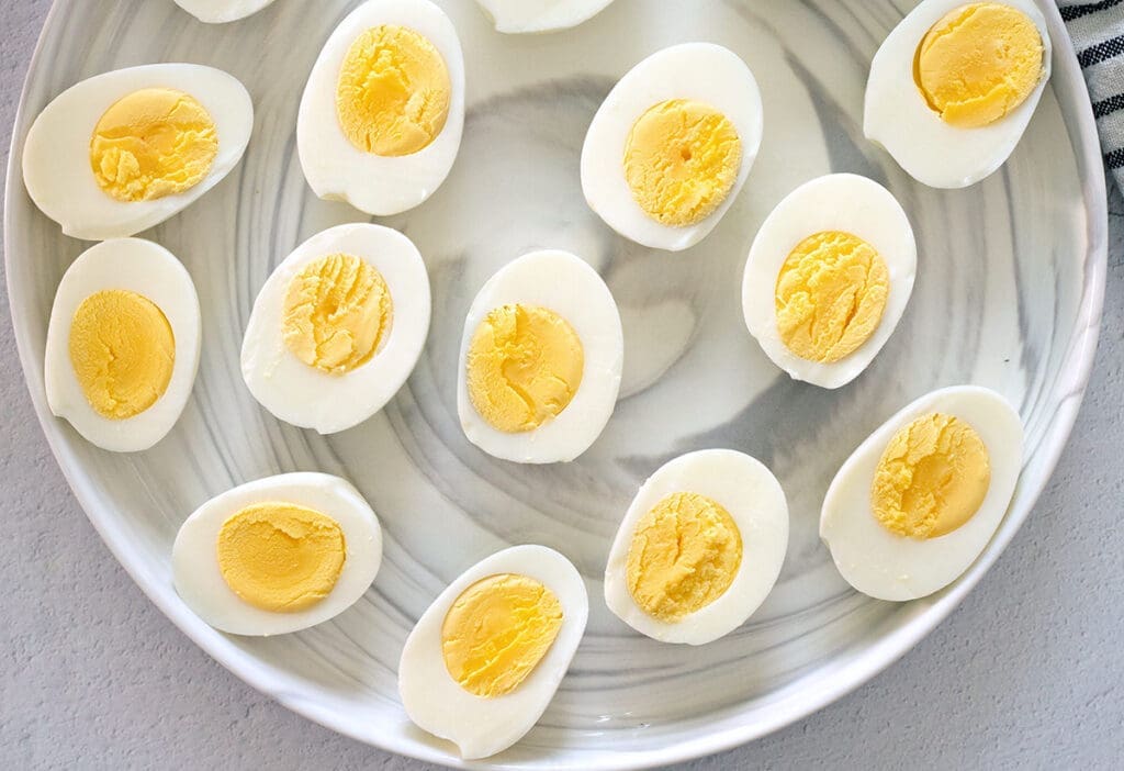 Plate of halved cooked eggs.