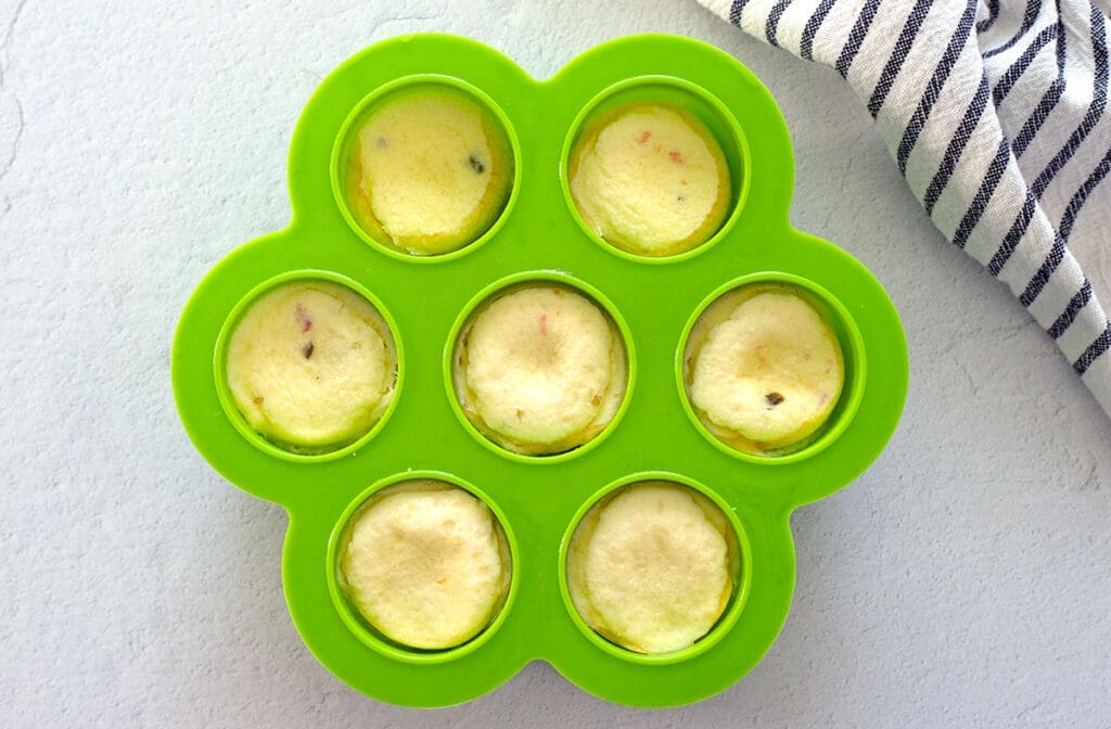 Cooked egg bites in a green silicon mold.