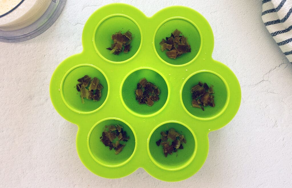 Silicon mold filled with bacon bits.