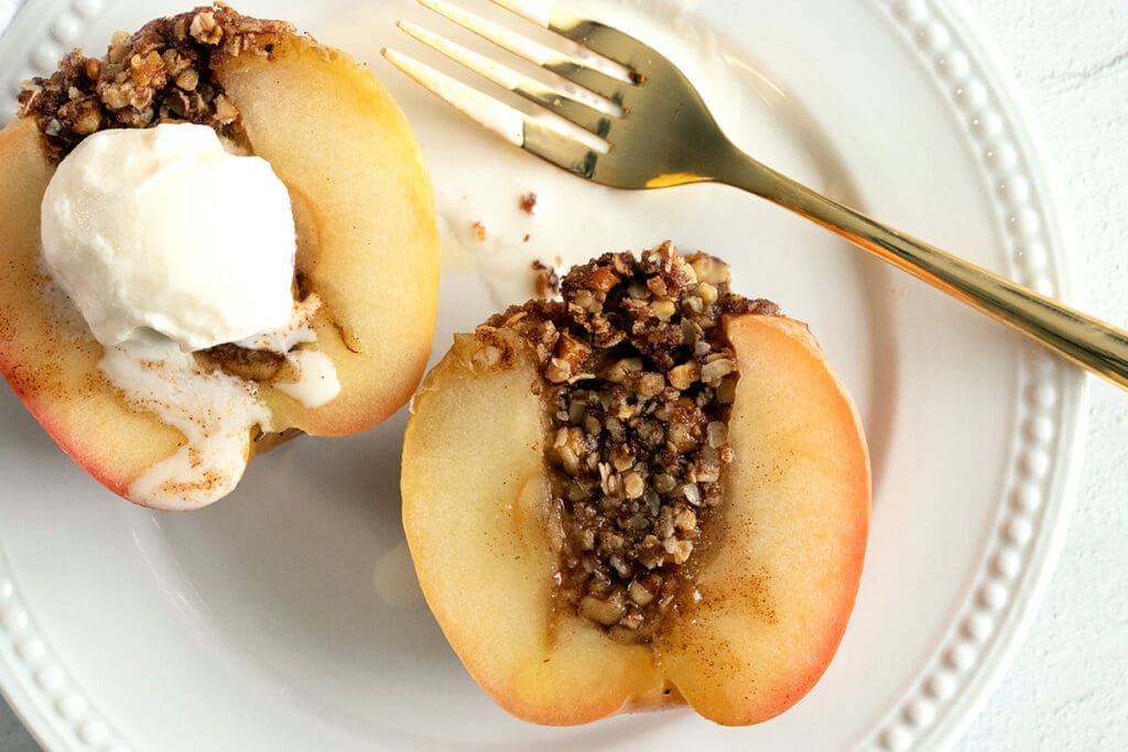 Stuffed honeycrisp on a white plate with a gold spoon.