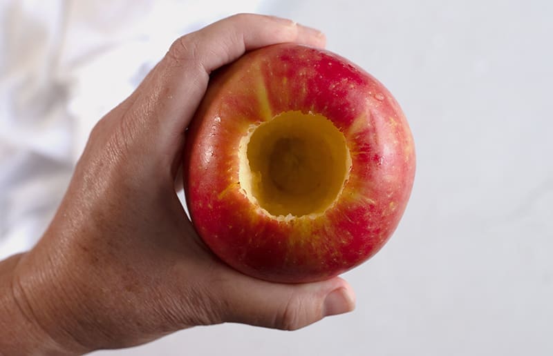 Cored apple being held in a hand.