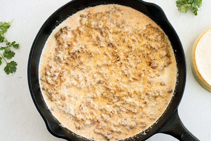 Choriqueso in a black cast iron skillet.