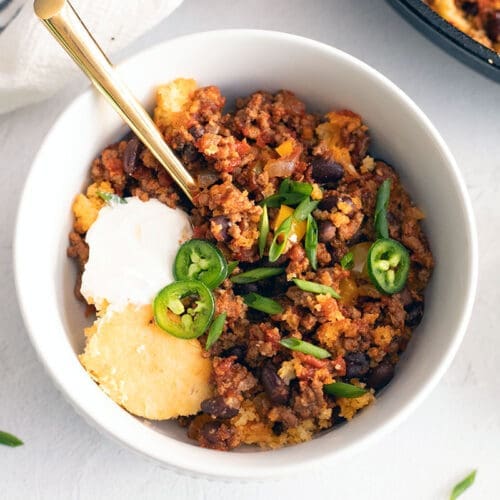 White bowl full of Chili with Cornbread.