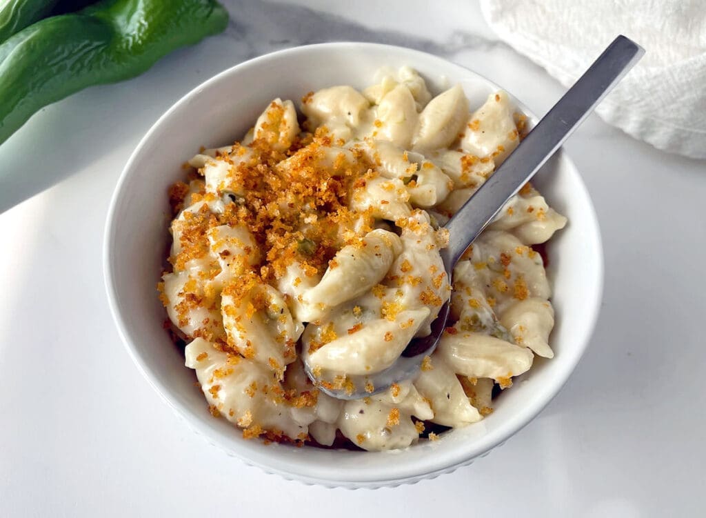 Bowl of green chile macaroni and cheese with a spoon.