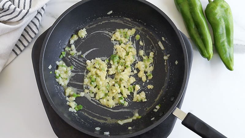 Peppers and onions in a black skillet.