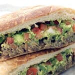 Carne asada torta cut in half and stacked.