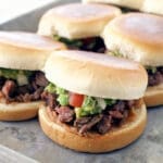 CARNE ASADA SLIDERS ON A SILVER BAKING SHEET.