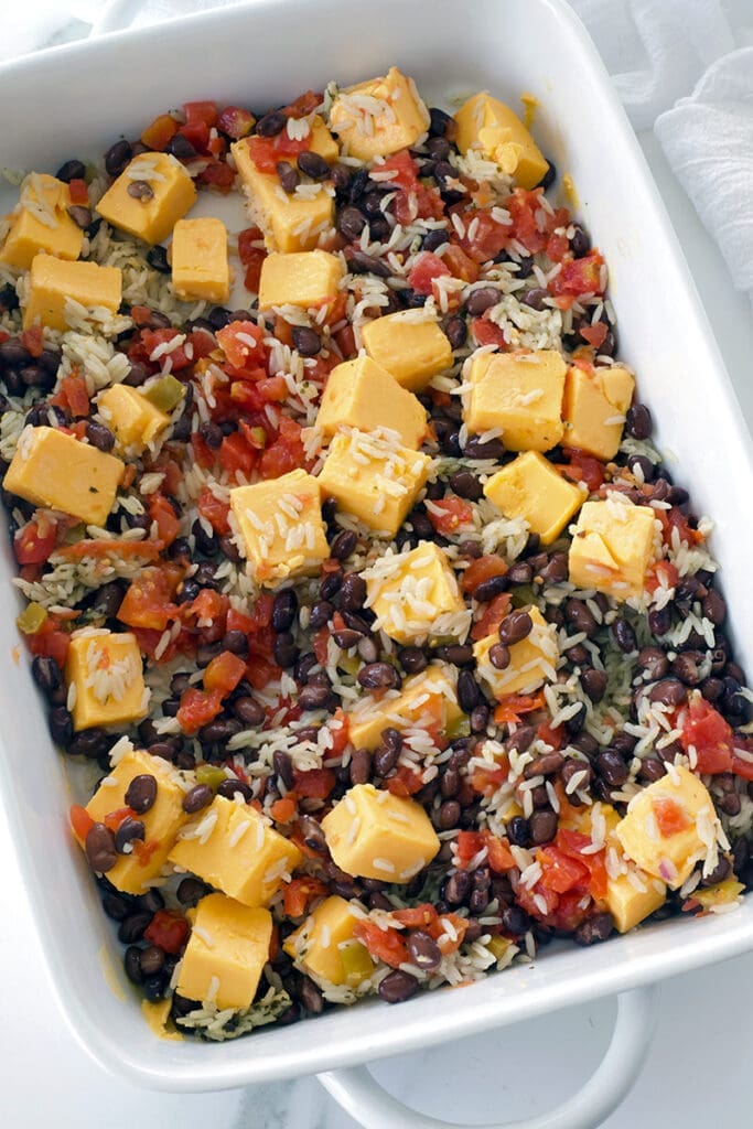The berbeta, beans and rice are mixed in a white baking dish.