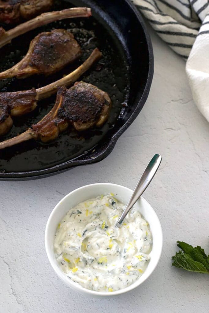 A bowl of lamb soaked sauce and a lamb lollipop.