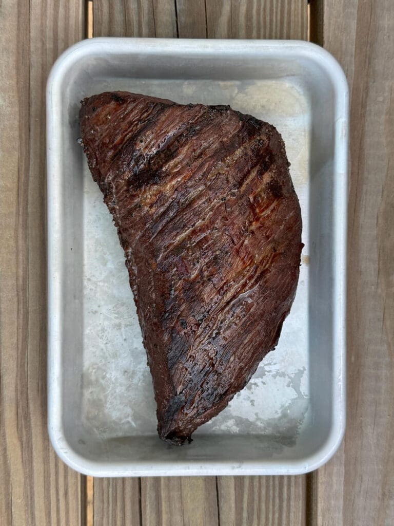 cooked tri tip roast on a silver baking sheet.