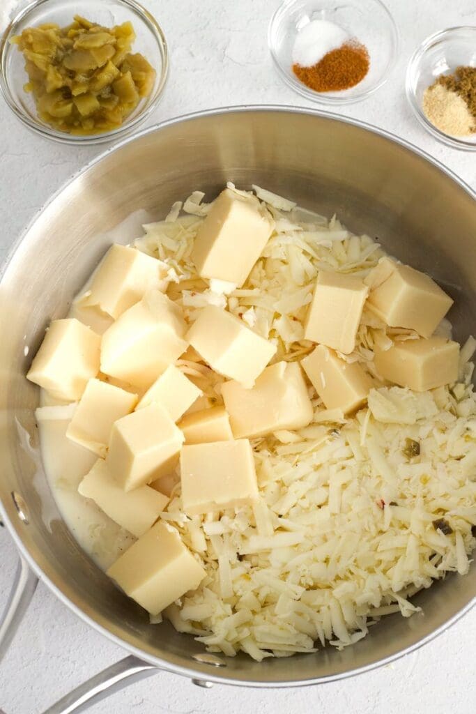 Two types of cheeses in a saucepan for How to keep queso smooth article.