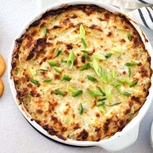 White baking pan with a hot dip inside next to ritz.