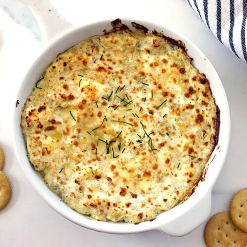 White baking dish with artichoke dip.