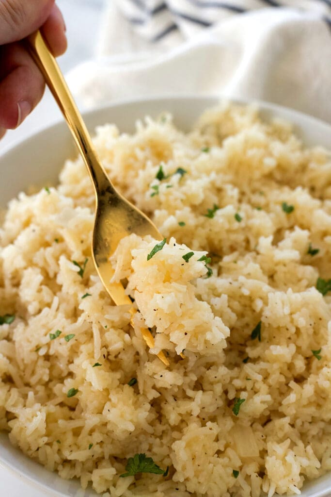 A golden fork that supports a mouthful of rice.