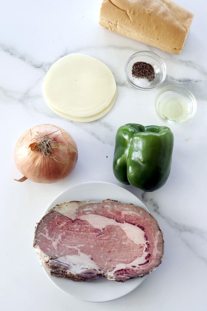 Labeled photo showing the ingredients to make a prime rib Philly cheesesteak.