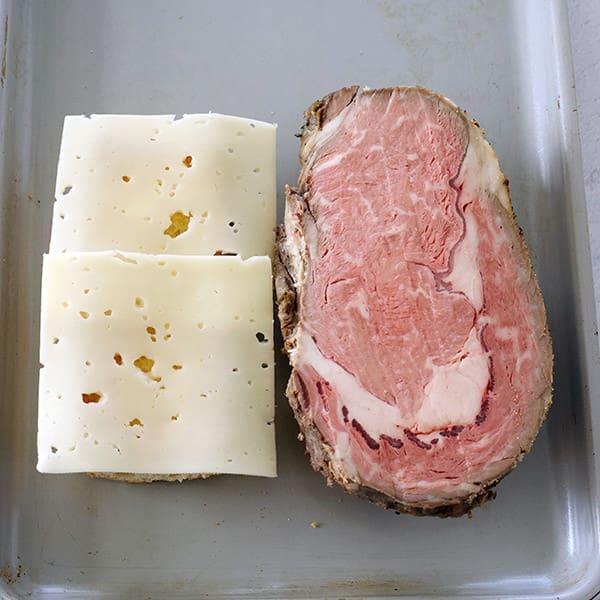 Slab of prime rib and slices of cheese.