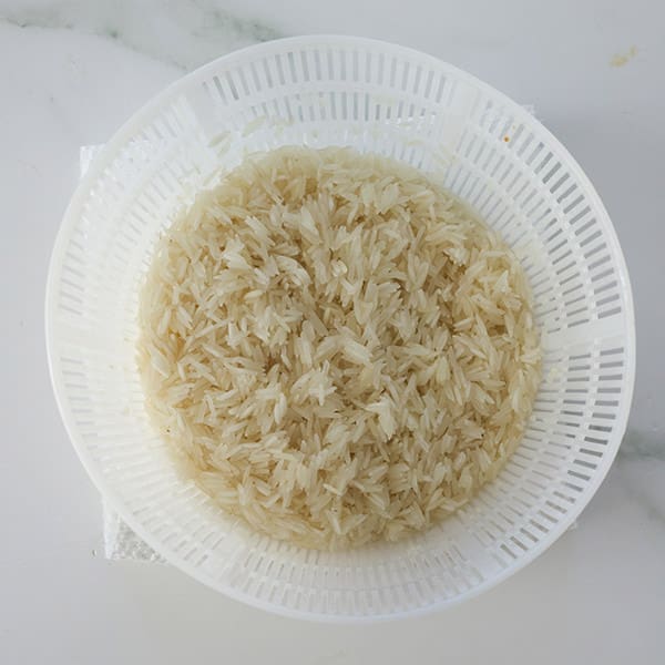 Rice in a white colander.