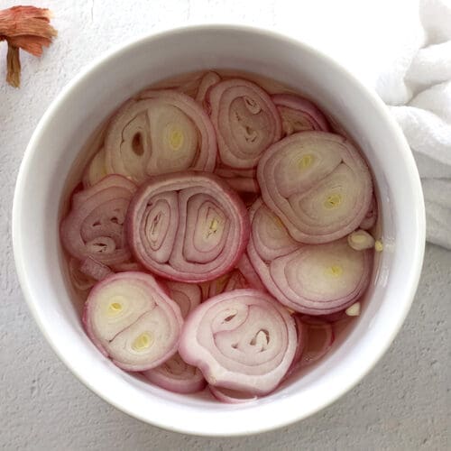 A white bowl with pickled shallots.