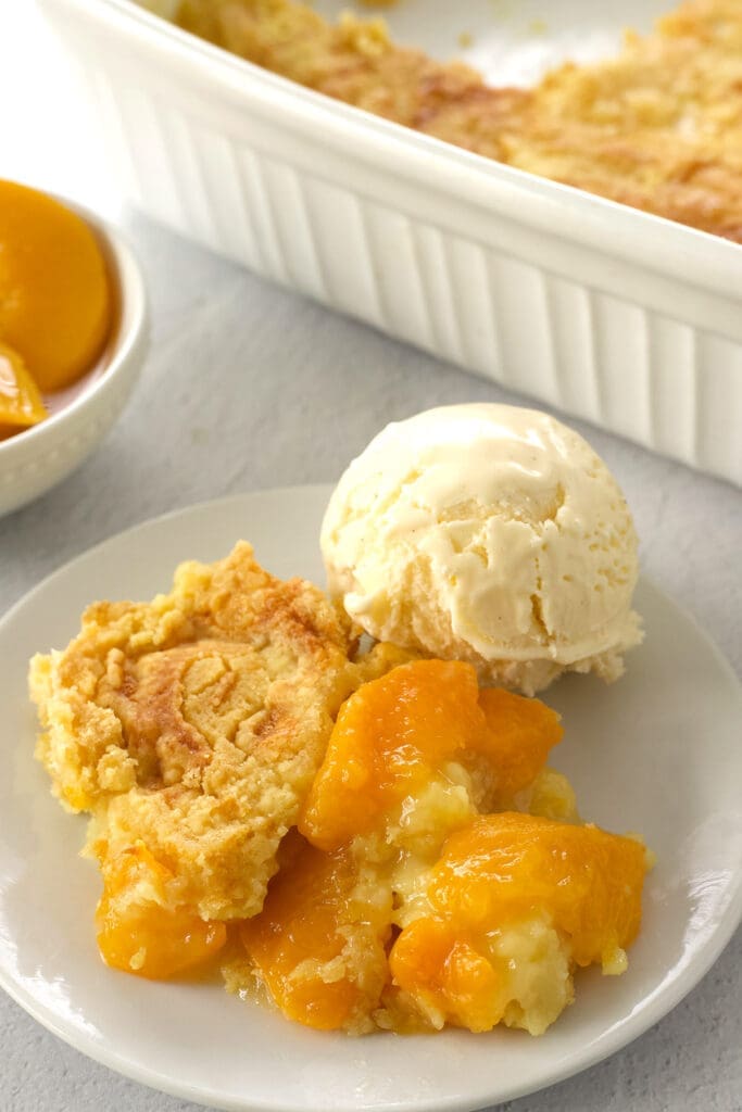 Slice of peach dump cake and ice cream.