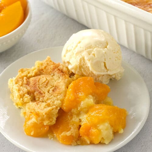 Slice of peach dump cake and ice cream.