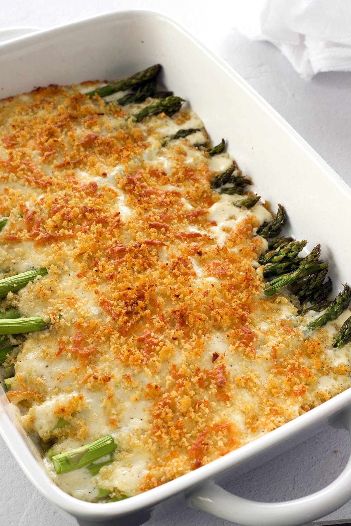 Baked asparagus casserole recipe in a white baking pan.