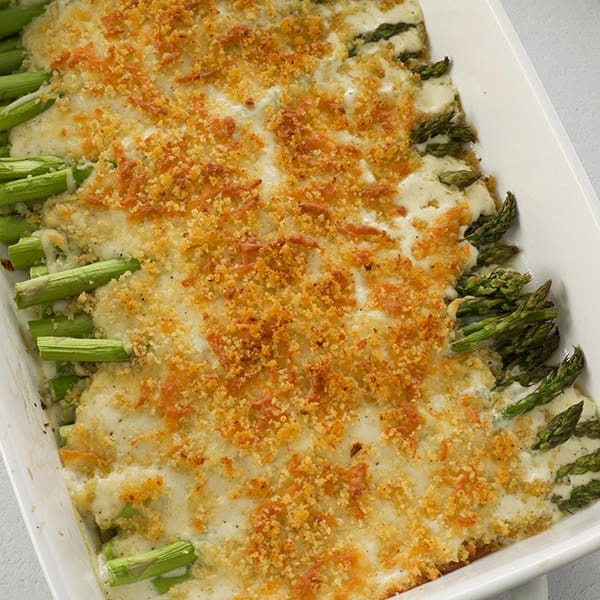 Baked asparagus casserole in a white baking pan.