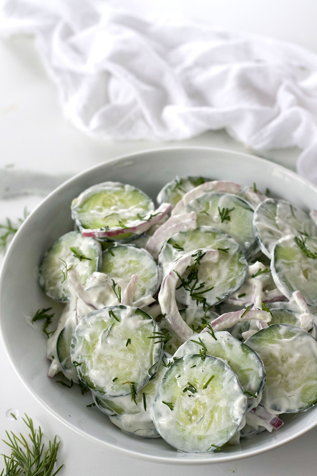 Ceramic bowl with creamy cucumber salad.