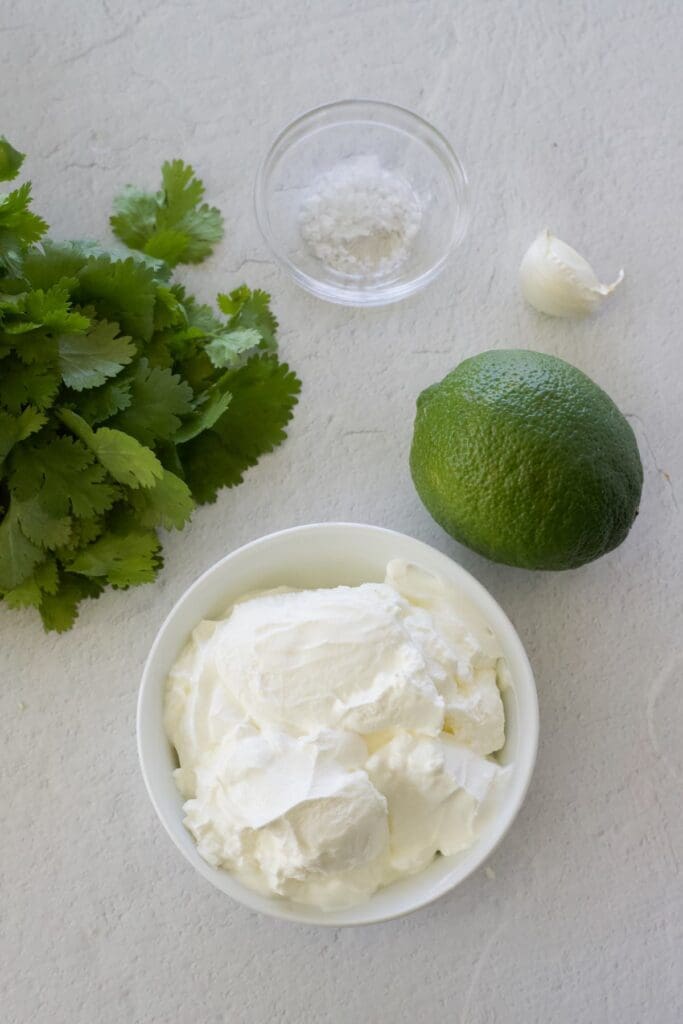 sour cream, lime, cilantro, salt and garlic for Cilantro Lime Crema.