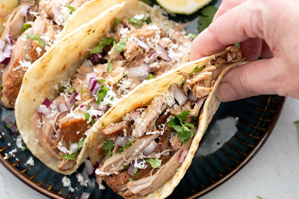 Hand picking up a Mexican taco.