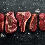 black board with the most tender cuts of beef raw on top.